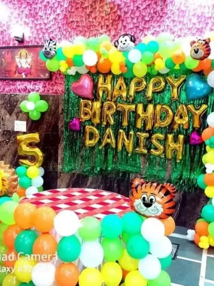 Another view of the colorful jungle theme for Danish's 5th birthday, showing the full balloon arch and backdrop.