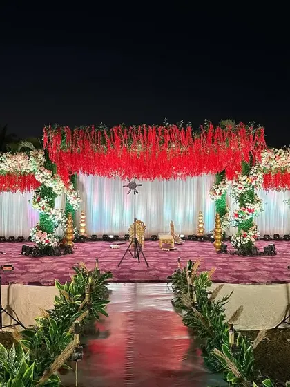 Another view of the stunning red floral ceiling reception stage, showcasing the scale and impact of the design. The lighting enhances the richness of the red, creating a vibrant and celebratory mood.