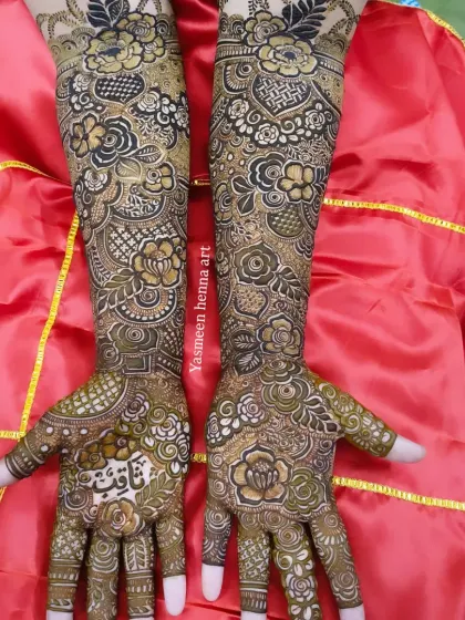 This bridal design features the groom's name, Saquib, written in beautiful calligraphy on the palm, surrounded by a garden of henna flowers.