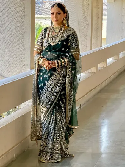 A royal bride in a deep green Manish Malhotra saree. I styled her hair in a classic updo to match the regal elegance of her outfit.