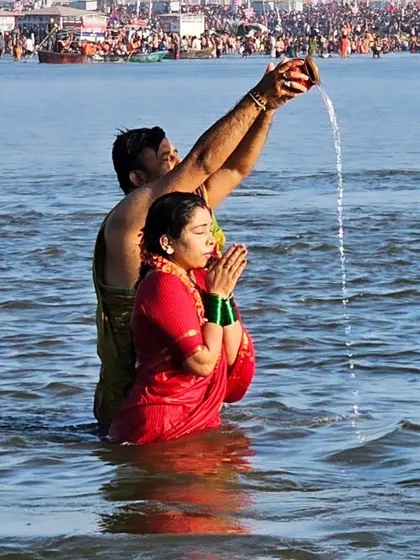Offering prayers to the holy rivers at Prayagraj. Such moments of shared devotion are the essence of a family pilgrimage.