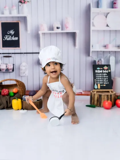 Exploring all the fun props in the mini kitchen. I provide everything needed for these creative toddler photoshoots.