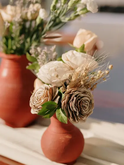A small terracotta vase with sola wood flowers, a sustainable and beautiful decor choice.