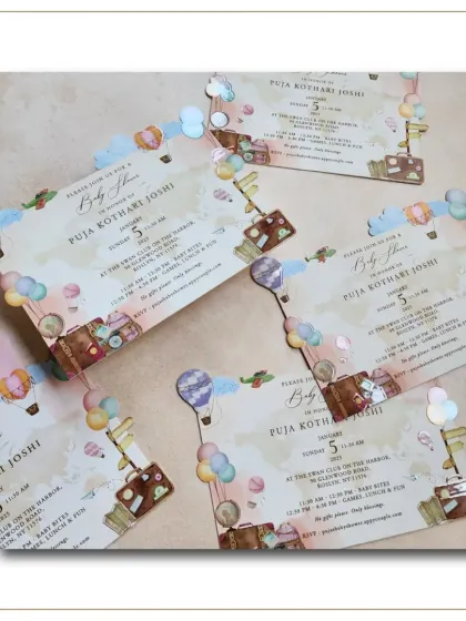 Another view of the 'adventure awaits' baby shower invitations, scattered to show the playful design and unique shape.