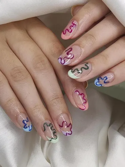 This design uses negative space with colorful, squiggly outlines on each nail. It's a fun, modern, and slightly retro look that is completely hand-painted.