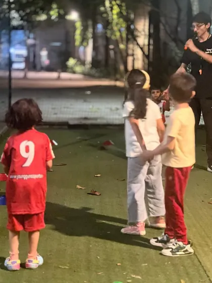A coach listens to a group of children during a break. These informal moments are important for building trust and understanding each child's personality.
