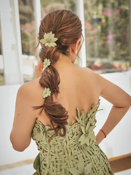 A close-up on the stunning hair detail for this look. The braided ponytail adorned with green leather flowers perfectly complements the Oscar de la Renta outfit.