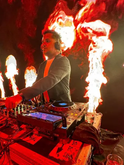 A side view of me at the console during the fire-themed after-party. I'm focused on the mix, ensuring a seamless flow of music.