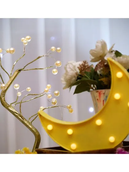 A whimsical light-up tree and moon prop add a magical glow to the decor.