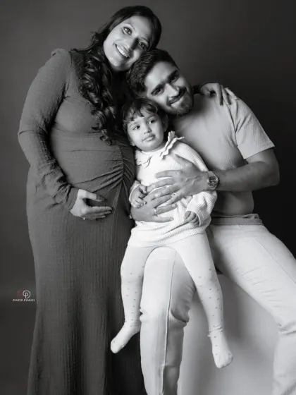 A happy family portrait, ready for their new addition. This black and white photo has a timeless feel, perfectly capturing the joy of this special time.