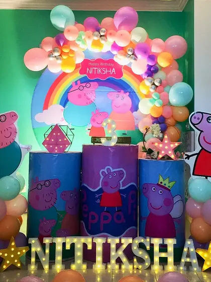 A fun-filled Peppa Pig party for Nitiksha. This colorful setup includes the whole Pig family, a rainbow backdrop, and bright balloons to capture the cheerful spirit of the show.