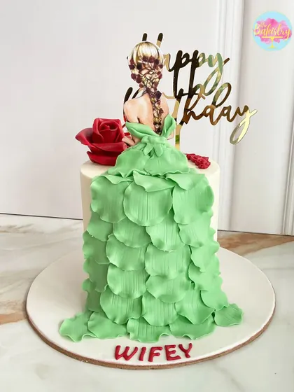A unique and elegant design for a "wifey," this cake features a beautiful 2D print of a girl with a flowing green dress made from delicate fondant petals.