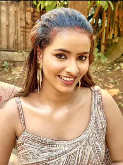 A happy close-up of a model in a sparkling beige gown.