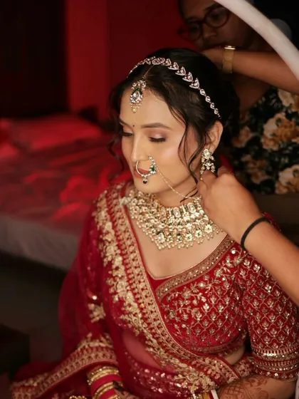 Final touches on a beautiful bride in her red lehenga. It's these moments of preparation that are so special.