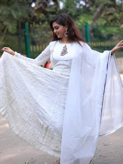 The flow and twirl of a full-length Anarkali is always so beautiful. This one is made from a textured fabric that adds depth and richness to the all-white look.