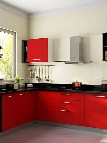 A classic L-shaped kitchen in a vibrant red finish. The black countertop and stainless steel appliances provide a modern edge to the bold color choice, creating a kitchen that is full of energy and personality.