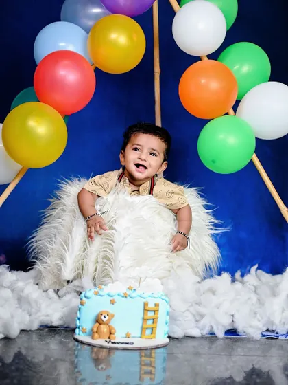 Up, up, and away! This hot air balloon theme is a whimsical and adorable concept for a first birthday shoot. The fluffy clouds, colourful balloons, and cute cake make for a magical setting.