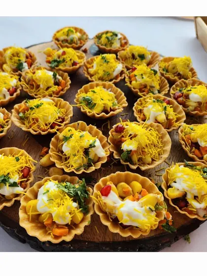 My chaat bites are a modern take on a classic favorite. Served in crispy tart shells and topped with sev and pomegranate, they are a burst of flavor in every bite.