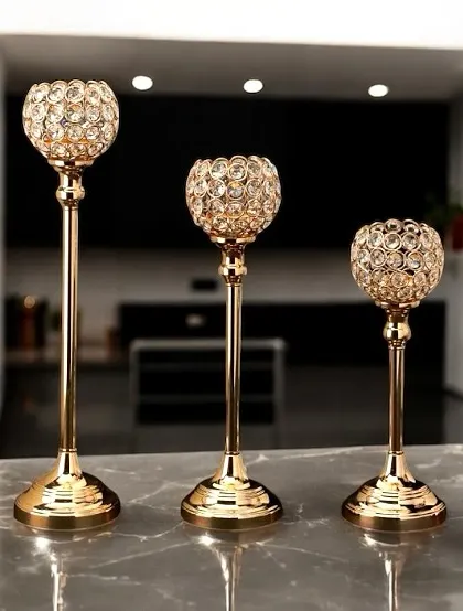 This set of three crystal candle holders adds a touch of glamour to any surface. The gold-finish stands and faceted crystal bowls catch the light beautifully, making them perfect for festive occasions or elegant dinners.
