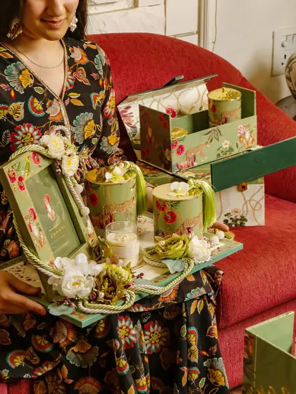 A moment of joy as a bride-to-be receives a curated hamper from the Tales of Tropic collection. The tray is filled with themed goodies, including a personalized photo frame, all designed to celebrate her unique story.