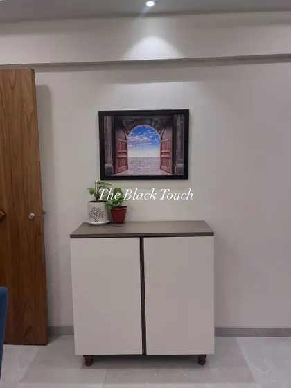 A simple yet elegant shoe cabinet placed near the entrance. This functional piece provides necessary storage while complementing the overall aesthetic of the home.