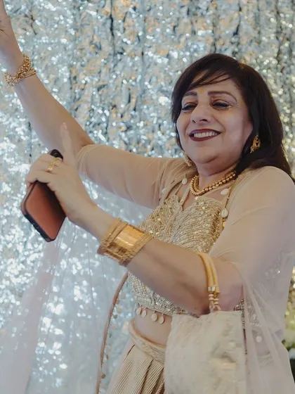 A guest dances with joy against a sparkling silver backdrop, showing how our decor creates photo-worthy moments everywhere.