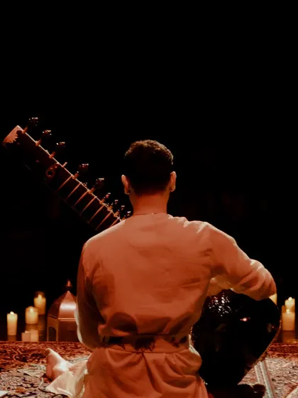 A view from behind, showing the immersive experience of being enveloped by candlelight and music.