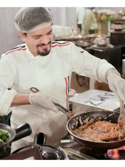 Our chefs are the heart of our culinary creations. Here, a member of our team is expertly preparing a dish at a live station, showcasing the passion and skill that goes into every meal we serve.