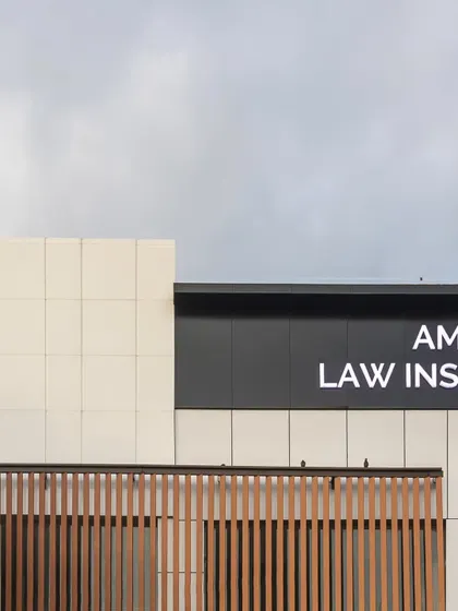The upper portion of the facade, highlighting the clean lines of the signage and the crisp contrast between the black and white panels. This detail contributes to the building's clear and confident visual identity.