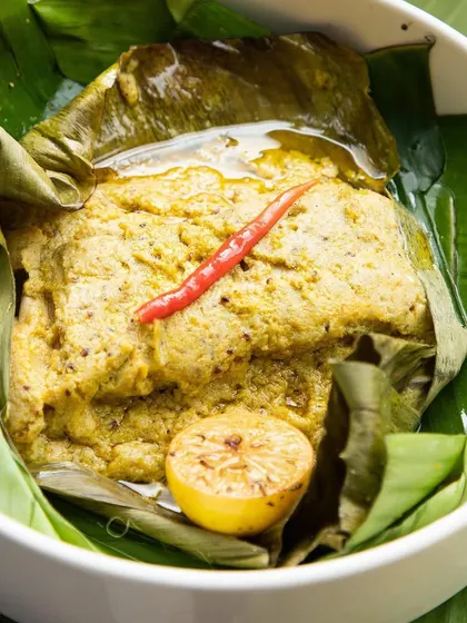 A close-up of the Maach Paturi, showing the tender fish coated in our flavorful raw mango mustard.