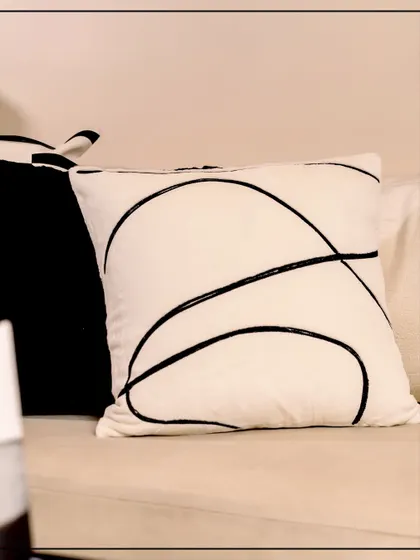 Awaken your interiors with the untamed beauty of Wild Noir. This cushion, featuring abstract black lines on a cream background, brings a dramatic edge to a refined and modern space.