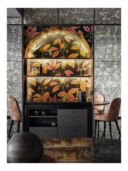 This discreet bar cabinet is hidden within a mirrored wall. When closed, it is almost inconspicuous. When open, it reveals a funky, wallpaper-clad bar, perfect for house parties. It's a prime example of our approach to functional, surprising design.