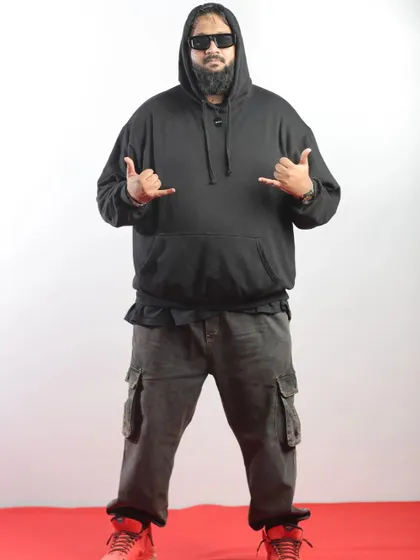 Rapper All OK posing for a studio-style shot at the event, showcasing his cool and casual style.
