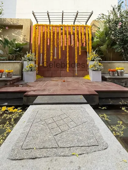 A simple and beautiful outdoor Haldi setup. We used marigold garlands against a rustic wall, with the stage set over a water body for a serene and picturesque ceremony.