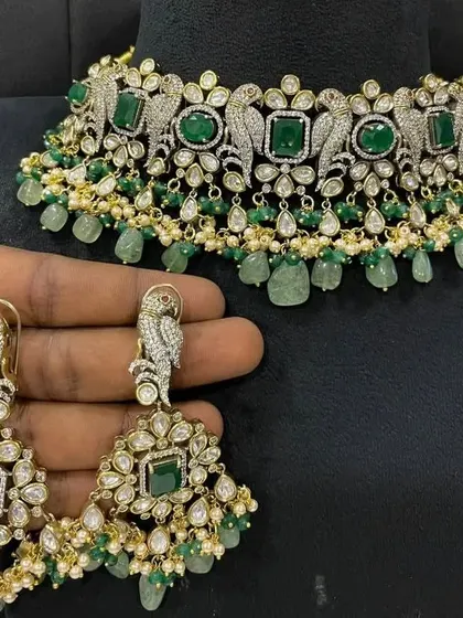 Make a statement with this unique Victorian choker featuring parrot motifs and green beads. The matching oversized earrings complete this bold and stylish set.