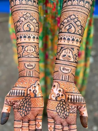 This design features graceful peacocks on the palms and arms, with the couple's names, Pratik and Komal, written in Hindi. It's a beautiful blend of artistry and personalization.