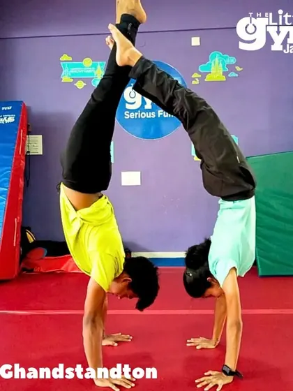 Teamwork makes the dream work. Two of our instructors demonstrate a partner handstand, showcasing the strength, balance, and trust we build in our classes.