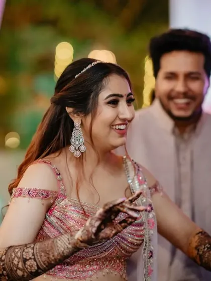 A candid shot of the bride dancing, her henna-covered hands in motion.