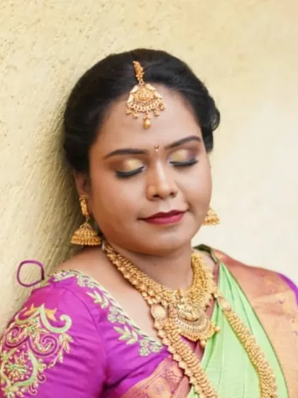 I curated this Muhurtham look for my friend's wedding. It features a classic golden eye makeup to match the heavy temple jewellery and a bright lip color that pops against her green and pink silk saree.