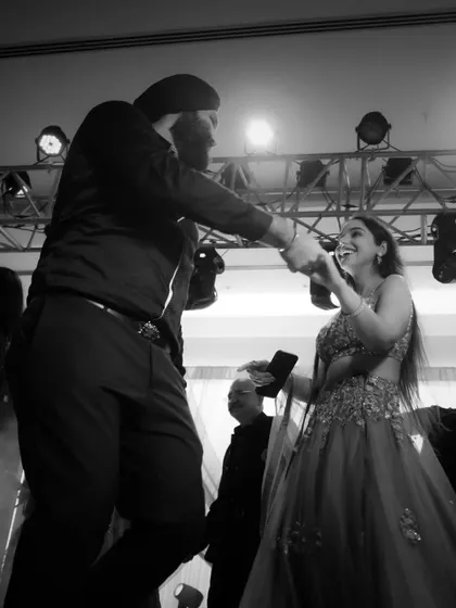 A joyful dance. The black and white format emphasizes the movement and the happy expressions of the couple.