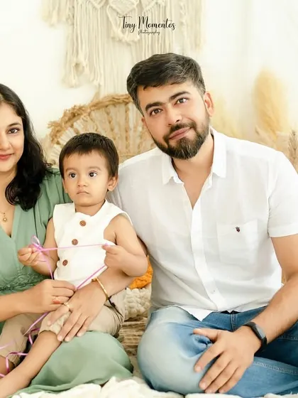 A calm and connected family portrait. The earthy green and white color palette complements the boho decor, creating a harmonious and peaceful image.