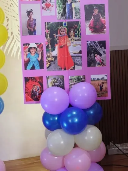 A personalized photo collage board used as part of a butterfly-themed party's decor.