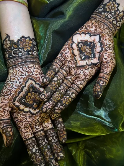 This design features a central mandala like pattern on the back of the hands, surrounded by delicate floral vines. It's a classic and elegant choice for any festive event.