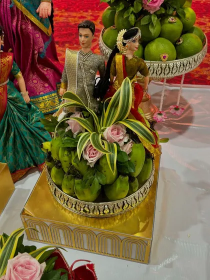A platter of green mangoes decorated with pink roses, perfect for a summer event.