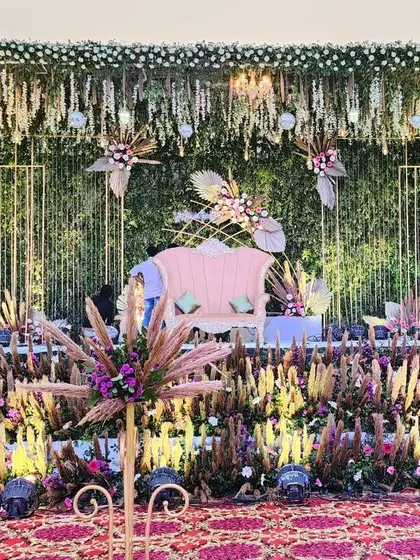 Another perspective of our textured floral stage, highlighting the pink lounge sofa and the artful arrangement of pampas grass and floral bursts. This design is perfect for a glamorous, boho-chic wedding.