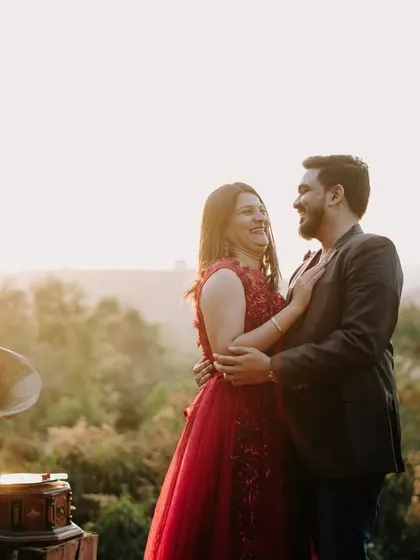 A joyful, candid moment of laughter and embrace, with the soft golden light of sunset creating a magical atmosphere in the hills.