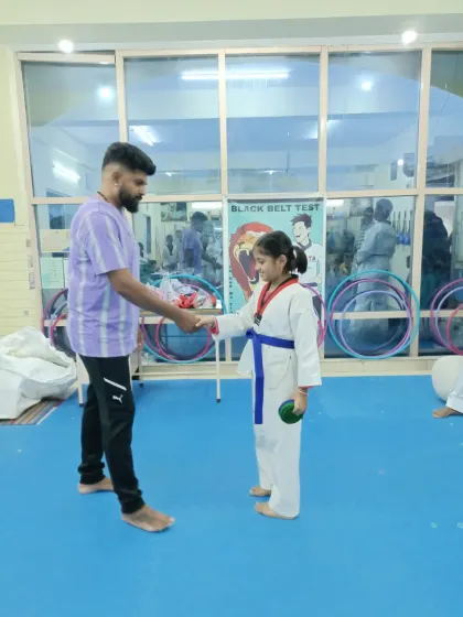 A young girl receives her blue belt.