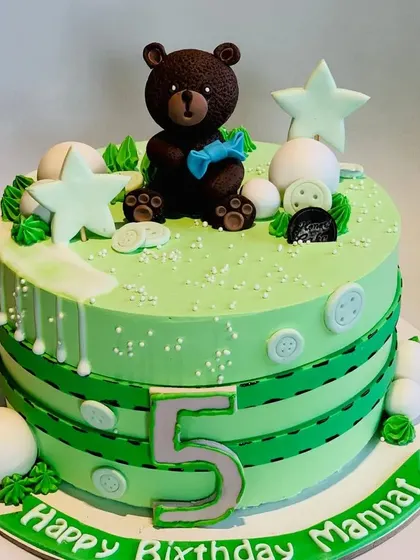 A cute teddy bear themed cake for Mannat's fifth birthday. The green cake is decorated with button and stitch details, giving it a unique and charming look.