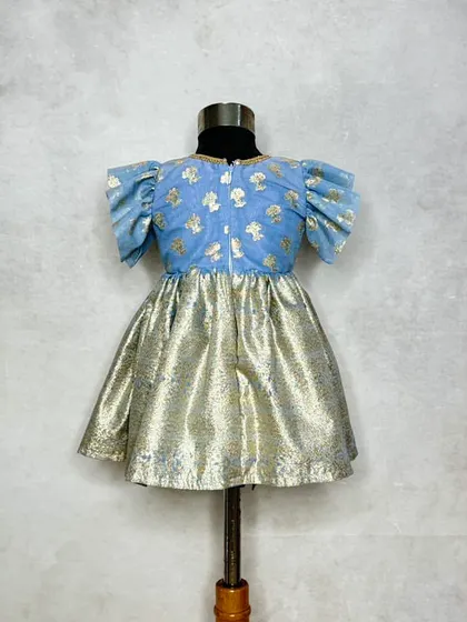The back view of the Mogra blue dress, showing the simple zip and flutter sleeves.