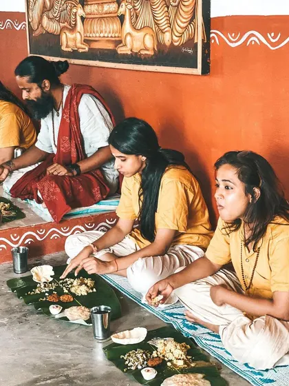 Students and teachers share a traditional South Indian meal served on banana leaves. Eating together in this way is a beautiful communal practice that fosters a sense of family and gratitude.